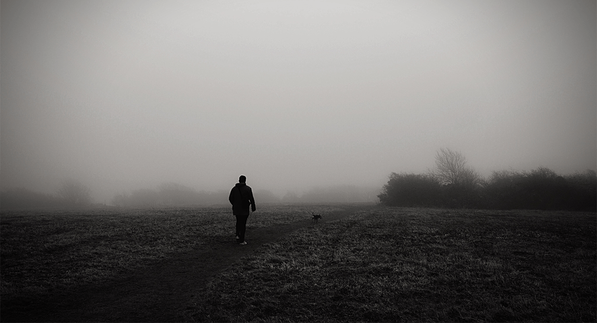 Hombre caminando solo en un campo abierto